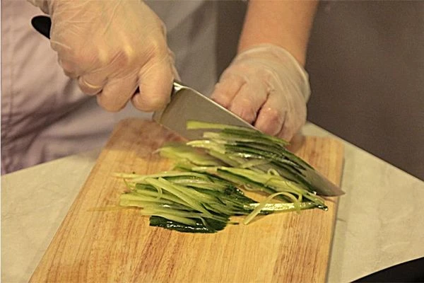 Порежьте кальмар и огурец длинной тонкой соломкой.