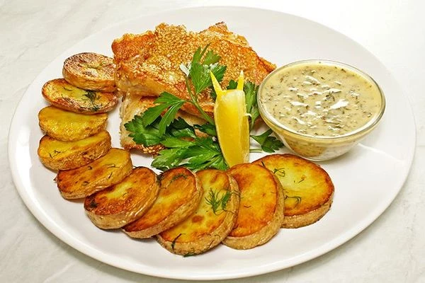 Подать готового окуня с жареным картофелем и соусом.