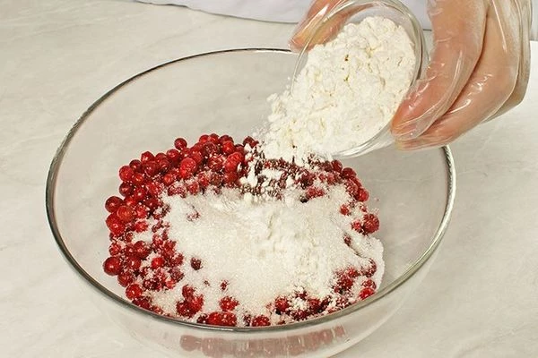 В это время приготовить начинку: смешать в чашке ягоду и сахар, всыпать муку