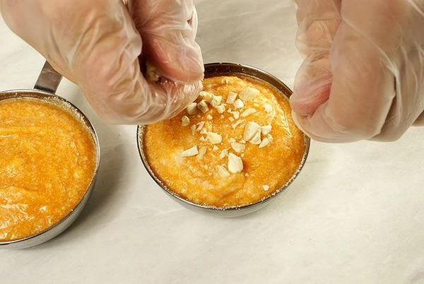 Выложить тыквенно-белковую массу  в формы и поставить выпекать в разогретую до 180С духовку на 20-25 минут, посыпав молотыми орешками и сахарной пудрой.