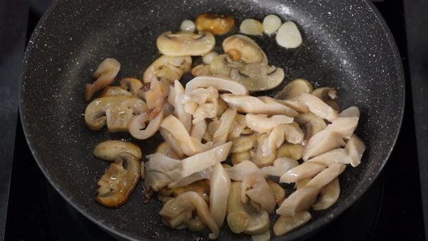 Выложить нарезанный гуидак, влить белое вино, увеличить нагрев, выпарить вино, перемешать, посолить. 