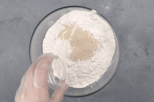 В глубокую чашку высыпать муку и дрожжи, перемешать. 