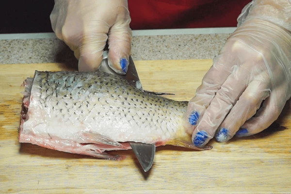 У карпа удалить голову, разрезать вдоль хребта, не дорезая до хвоста.
