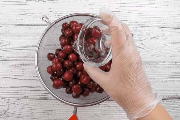 Вишню разморозить, выложить на сито, чтобы стекла лишняя жидкость и сок. Затем сбрызнуть ромом и оставить минут на 15. 
