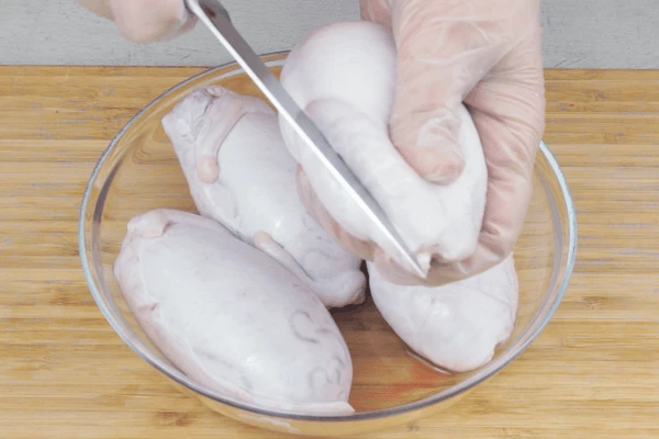 Семенники разморозить естественным способом на нижней полке холодильника. Замочить в холодной воде. По центру сделать неглубокий надрез, чтобы можно было подцепить оболочку и аккуратно снять кожицу. Затем еще раз промыть под холодной водой. 