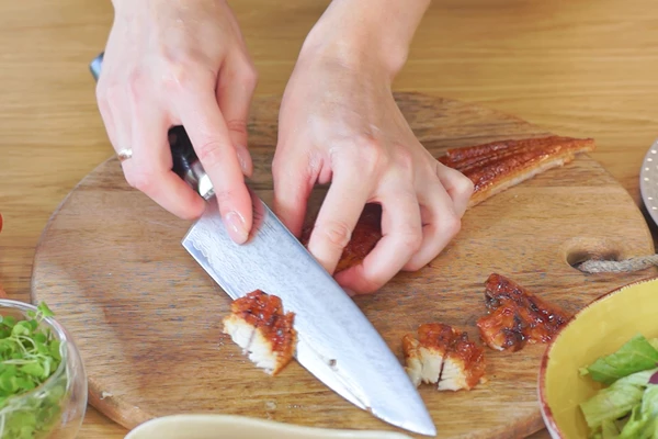 Угорь дефростировать на нижней полке холодильника. Освободить от соуса, снять кожу, нарезать наискосок тонкими слайсами.
