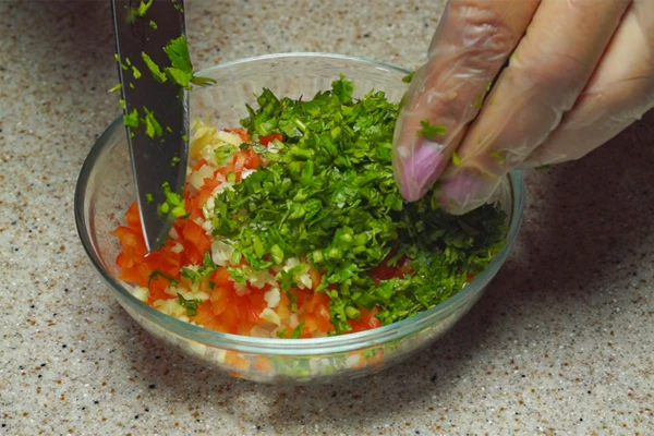 Лук и красный перец нарезать небольшим кубиком, чеснок и кинзу мелко порубить. Смешать в чашке.