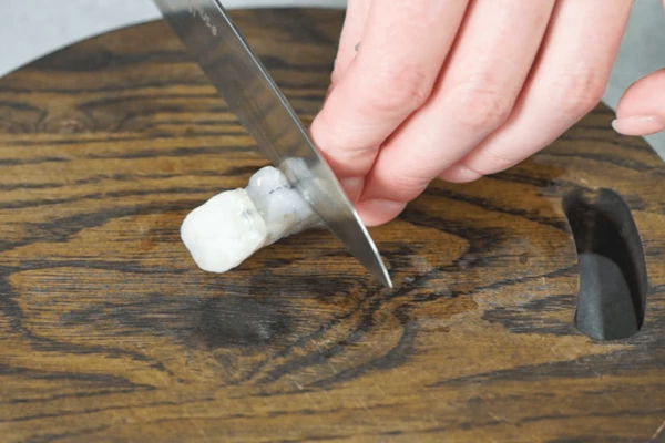 Креветки разморозить на нижней полке холодильника. Ножом с внутренней стороны креветки сделать поперечные надрезы, не перерезая креветку.