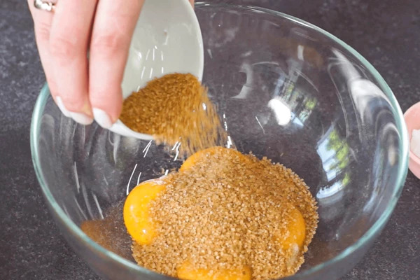 Желтки смешать с сахаром (70 гр.) и взбить до воздушной белой массы.