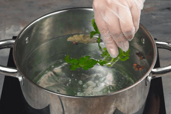 В большую кастрюлю налить воды, довести до кипения, добавить крупную морскую соль, несколько горошин душистого перца, лавровый лист. Можно добавить зелень петрушки или укропа, как при варке раков. 