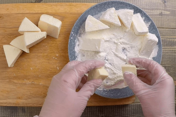  Сыр нарезать крупными треугольниками, обвалять в крахмале. 