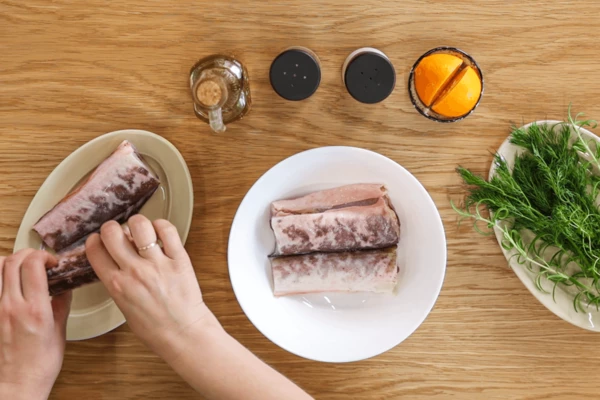 Рыбу разморозить естественным способом на нижней полке холодильника, промыть, разрезать на 2-3 части. Сложить в глубокую миску.