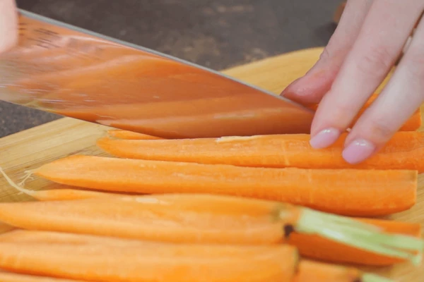 Морковь вымыть, очистить, нарезать на 4 части.