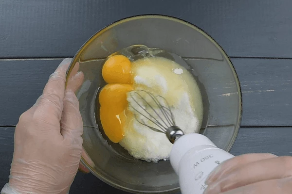 В глубокой чашке смешать сахар и яйца, хорошо перетереть венчиком