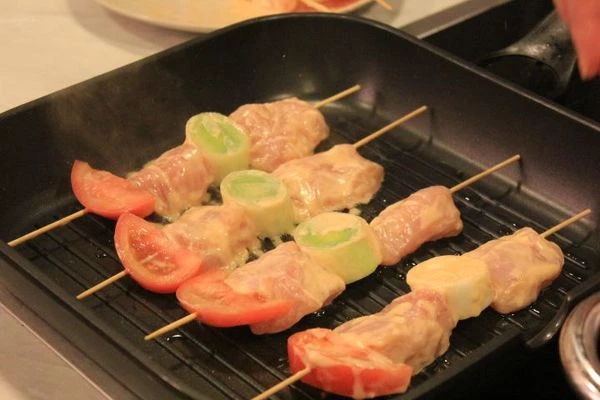 Нанизать на шпажки с кольцами лука порея. Обжарить на разогретой до 175С сковороде-гриль с двух сторон по 3-4 минуты.