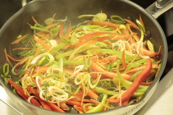 На разогретой с оливковым маслом сковороде обжарить белые грибы до полуготовности, посолить, поперчить, затем добавить овощи, мелко нарезанную зелень. Обжарить до мягкости овощей.