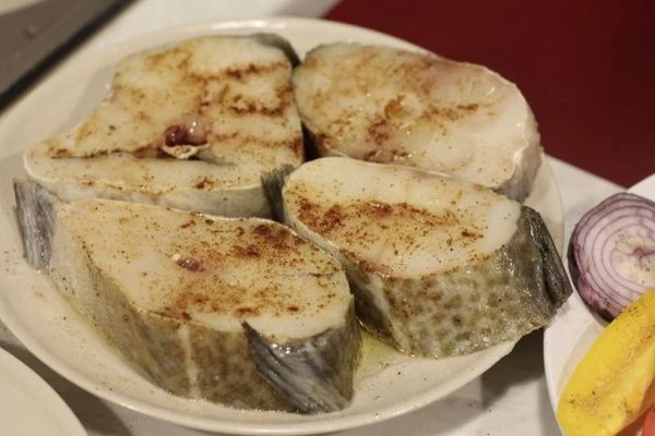 Стейки трески разморозить естественным способом на нижней полке холодильника на дренаже. Обсушить бумажным полотенцем. Посолить, поперчить, замариновать в оливковом масле на 5-7 минут.