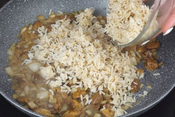 Грибная начинка: рис отварить до готовности, лук репчатый нарезать крошкой, грибы нарезать небольшими кусочками. На разогретой с растительным маслом сковороде обжарить лук и грибы, посолить, поперчить, добавить рис, прогреть пару минут и снять с огня. По желанию можно добавить мелко нарезанную зелень.