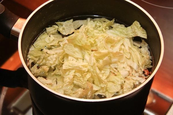 Приготовить бульон на основе комбу и грибов шиитаке. Пекинскую капусту нарезать тонкой соломкой, удалив жёсткие части, и отварить в бульоне до полу готовности