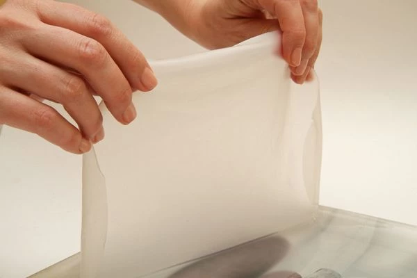 Бамбуковый коврик макису завернуть в пищевую плёнку. Подготовить широкую миску с водой.
