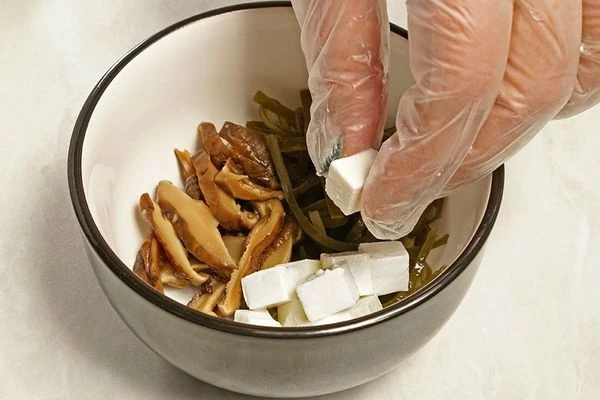 Выложить в чашку для мисо рыбу, творог тофу, грибы шиитаки, морковь. 