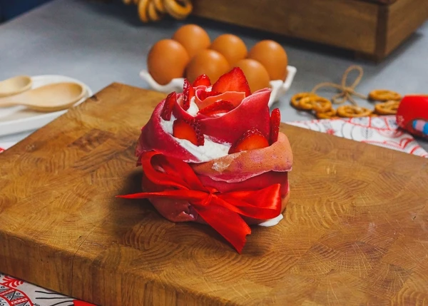 Для декора связать лентой. Оформить слайсами клубники. 