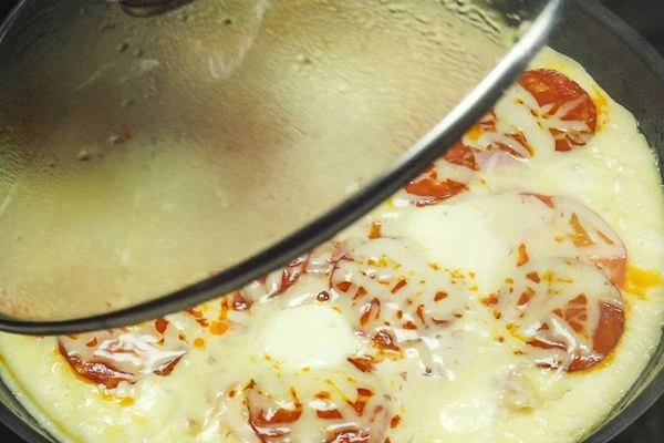 Поставить на слабый огонь, накрыть крышкой. Готовить 12-15 минут.