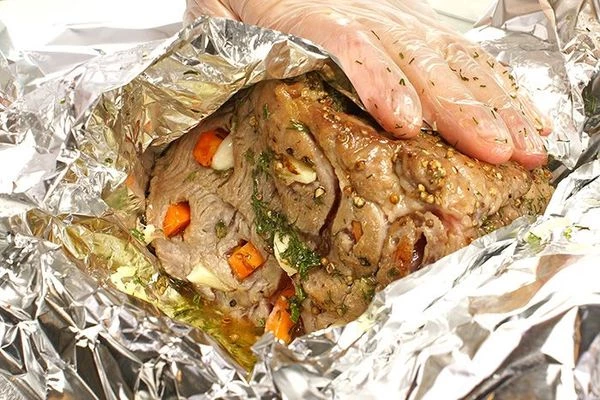 Обмазать пряной смесью мясо, плотно завернуть фольгой.