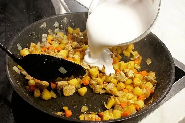 Влить кокосовое молоко, добавить 1-2 стручка чили перца, очищенного от семечек. Потушить до готовности овощей и мяса.