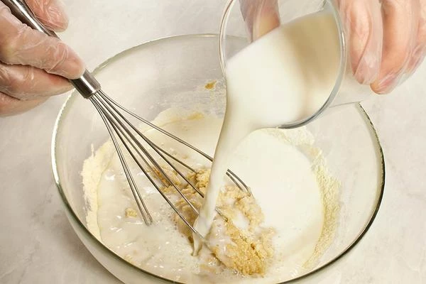 Влить теплое молоко, размешать до однородной консистенции.