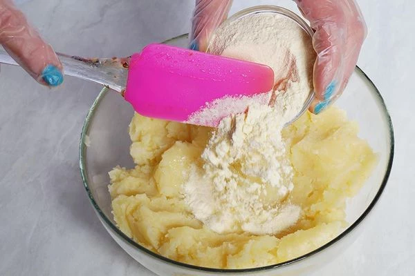 В теплое картофельное пюре добавить муку, хорошо перемешать.