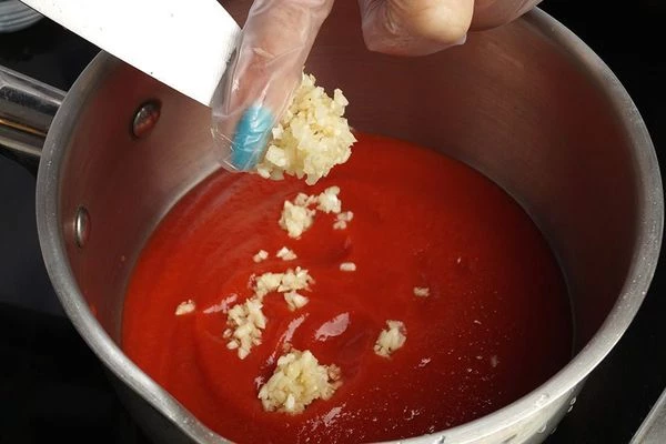 В небольшой кастрюльке смешайте томатный соус и натертый чеснок.