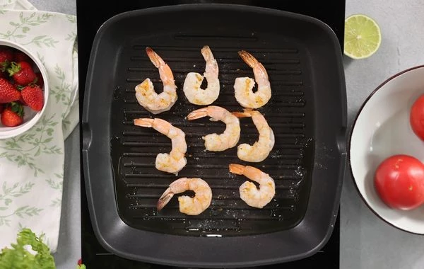 Креветки разморозить, обжарить на гриле с добавлением оливкового масла. Посолить.