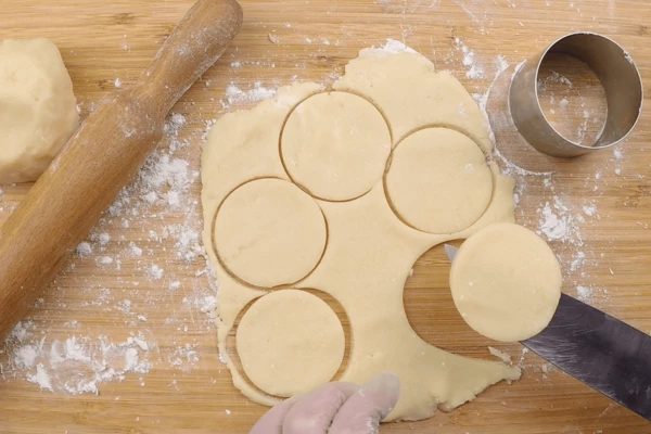  Готовое тесто раскатать толщиной 0,5см, с помощью формы вырезать печенье. 