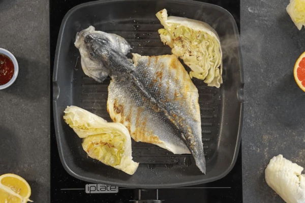 Подготовленную рыбу  и айсберг обжарить на гриле с добавлением масла с двух сторон, посолить и поперчить. При необходимости довести сибас до готовности в духовом шкафу при температуре 185 градусов в течение 5 минут.
