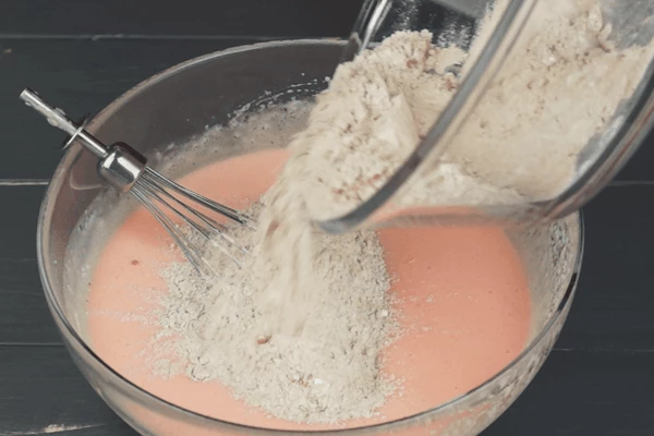 Затем добавить муку, перемешать до однородной консистенции, влить оставшуюся ряженку и еще раз пробить венчиком