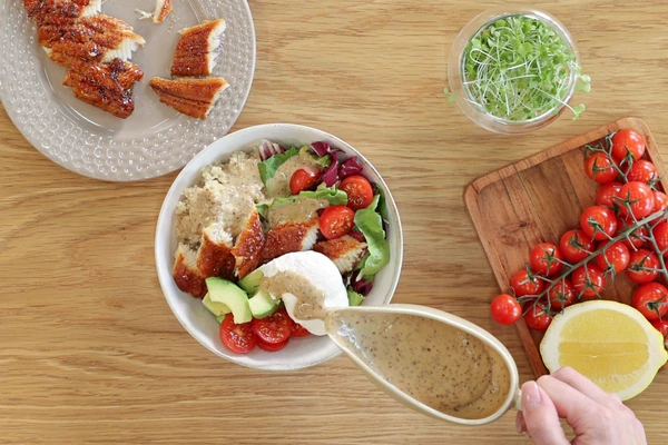 В тарелку для подачи выложить киноа, микс листьев салата или свежий шпинат, угорь, яйцо-пашот, авокадо, томаты-черри. Посолить. Полить соусом.