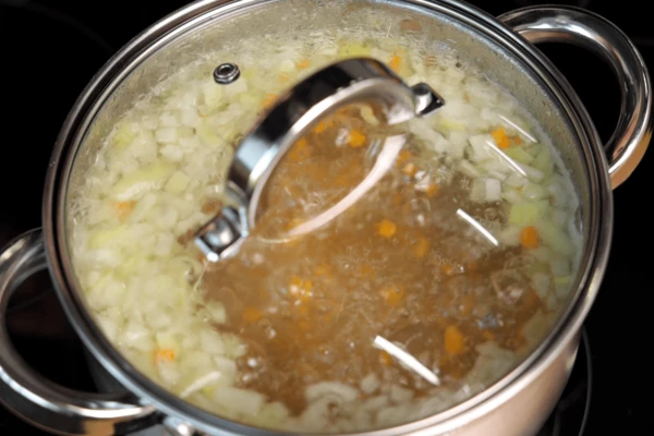 В бульон добавить картофель, морковь и лук, варить до готовности (~20 минут), довести до вкуса солью, перцем. 