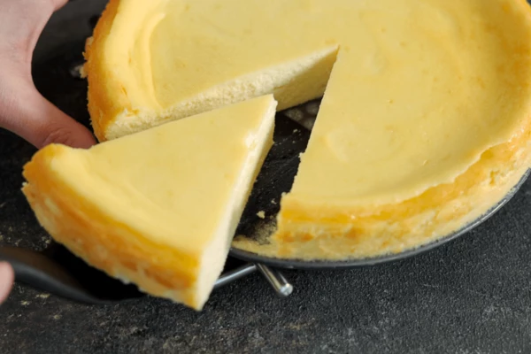 Готовый чизкейк достать из духовки, дать остыть при комнатной температуре. Нарезать на кусочки.
