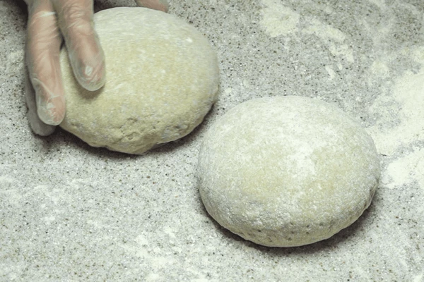 Тесто хорошо обмять руками, разделить на 2 шара. Накрыть и еще оставить на 2-2,5 часа для подъема.