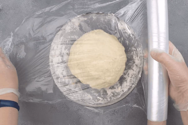  Из готового теста сформировать шар, накрыть пищевой пленкой и поставить в теплое место, чтобы оно поднялось в 2-3 раза. Затем тесто еще раз хорошо обмять, чтобы выпустить все пузырьки воздуха.  Распорционировать на шарики (у нас получилось 7 штук, можно сделать меньше по размеру), дать постоять, чтобы тесто поднялось. 