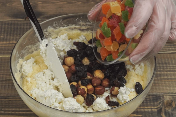 Добавить к масляной основе. Всыпать изюм, орехи и цукаты.