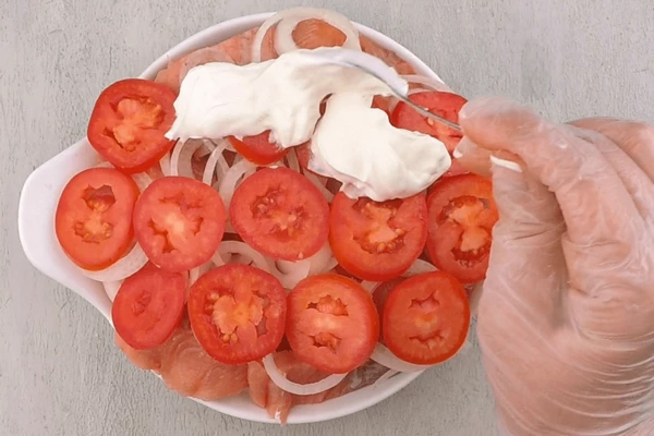  На лук уложить помидоры, смазать слоем сметаны. Поставить в разогретую до 190С духовку на 15-20 минут