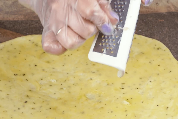 Смазать маслом. Сверху распределить натертый чеснок.