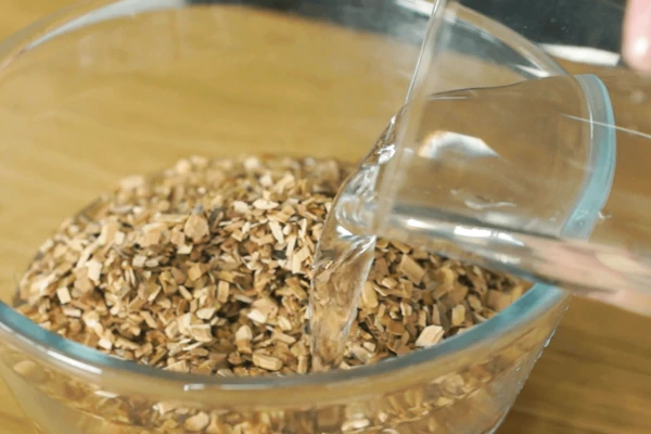 Опилки залить холодной водой на 15 минут, затем слить лишнюю воду.