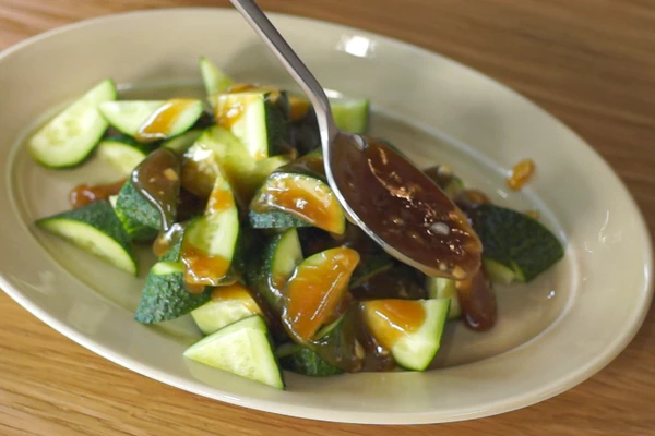 Огурцы нарезать произвольными кусочками, затем залить получившейся заправкой и дать постоять 10-15 минут.