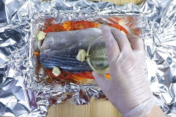 Выложить кусочки оставшегося сливочного масла. Полить по всей поверхности белым вином. 