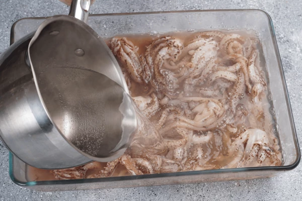 Щупальца кальмара разморозить естественным способом, на нижней полке холодильника. Затем залить горячей водой на 1 минуту.