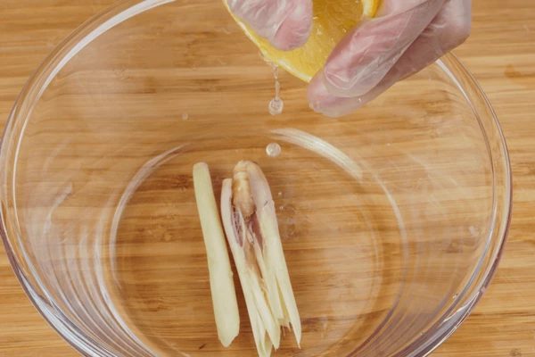 В чашку выложить палочки лемонграсса, выдавить лимонный сок.