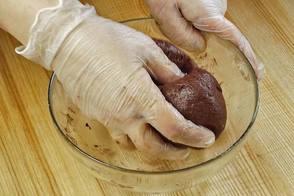 К сухой смеси добавить размягченное масло, перемешать. Затем влить яичную смесь, замесить тесто.